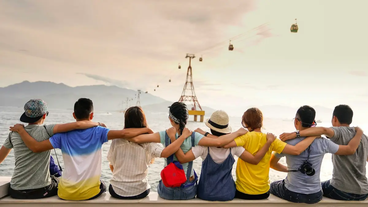 Friends sitting arm in arm watching the sunset