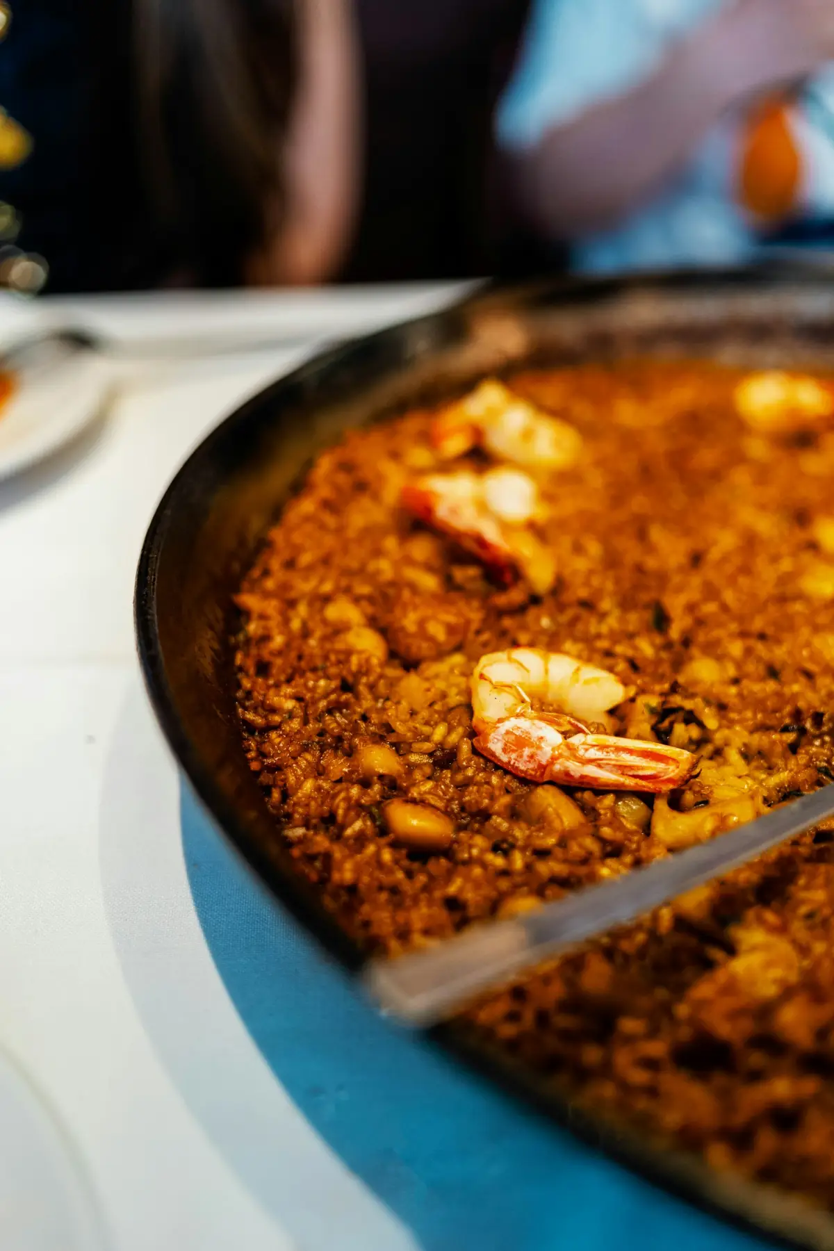 Golden paella being served from a pan with a spoon